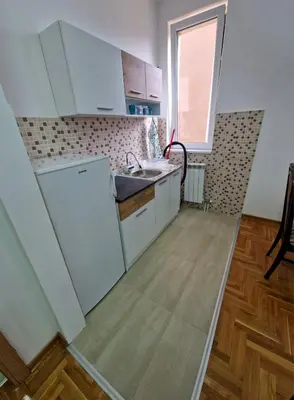 a kitchen with white cabinets and a sink at Tami in Belgrade