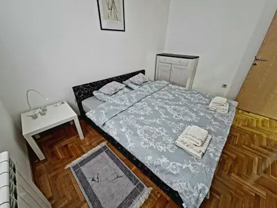 a small bedroom with a bed and a table at Tami in Belgrade