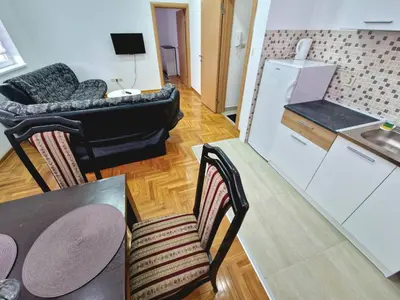 a living room with a table and a kitchen at Tami in Belgrade