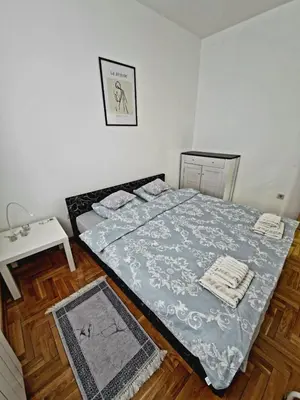 a small bedroom with a bed and a table at Tami in Belgrade