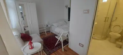a white living room with a couch and a table at Tsar Dušan Apartment in Belgrade