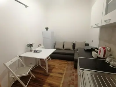 a kitchen with a table and a couch in a room at Tsar Dušan Apartment in Belgrade