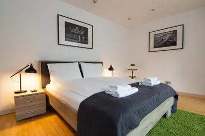 a bedroom with a large bed with towels on it at ZIGZAG Belgrade in Belgrade