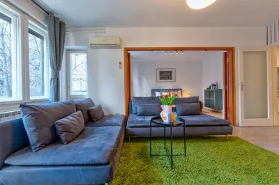 a living room with two blue couches and a table at ZIGZAG Belgrade in Belgrade