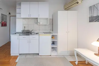 a white kitchen with white cabinets and a sink at Downtown nest in Belgrade