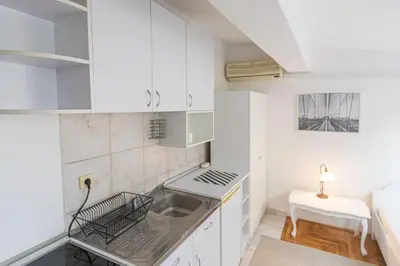a kitchen with white cabinets and a sink at Downtown nest in Belgrade