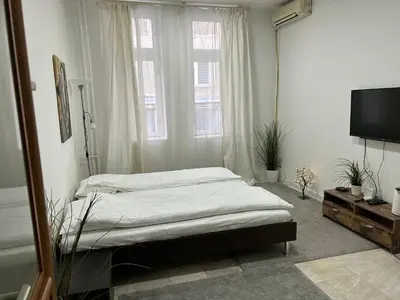 a bedroom with a bed and a large window at Nikolas 2 in Belgrade