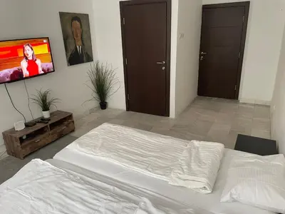 a bedroom with a white bed and a flat screen tv at Nikolas 2 in Belgrade