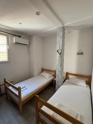 two twin beds in a room with a window at Apartments and Rooms L E F T RIVER Belgrade in Belgrade