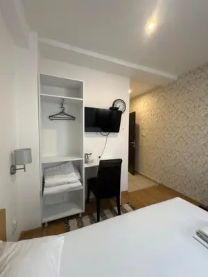 a bedroom with a bed and a desk with a chair at Apartments and Rooms L E F T RIVER Belgrade in Belgrade