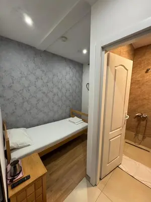 a small room with a bed and a bathroom at Apartments and Rooms L E F T RIVER Belgrade in Belgrade
