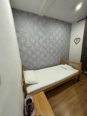 a small bed in a room with a wall at Apartments and Rooms L E F T RIVER Belgrade in Belgrade