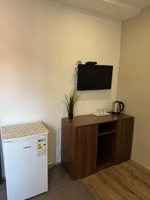 a room with a refrigerator and a flat screen tv at Apartments and Rooms L E F T RIVER Belgrade in Belgrade
