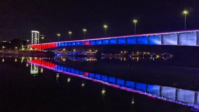 a bridge with colorful lights on the water at night at Belgrade Waterfront Victory Gardens in Sajmište