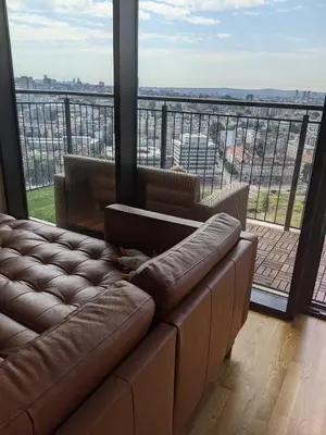 a living room with a couch and a large window at Belgrade Waterfront Victory Gardens in Sajmište