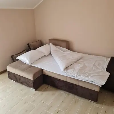 a large bed in a room with a wooden floor at Apartman Dalmacija in Ečka
