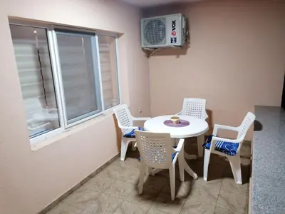 a small kitchen with a table and chairs and a window at Apartman Dalmacija in Ečka