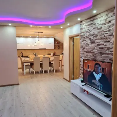 a living room with a tv and a dining room at Apartman Dalmacija in Ečka