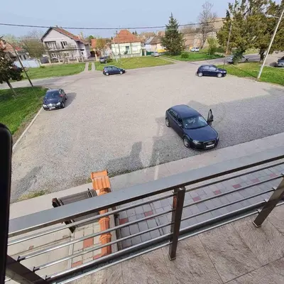 a parking lot with cars parked in a parking lot at Apartman Dalmacija in Ečka