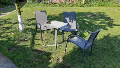 three chairs and a table in the grass at Fly in Dobanovci