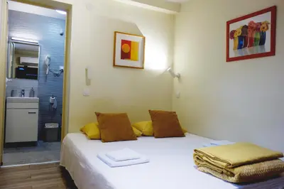 a bedroom with a bed and a bathroom with a shower at Villa Loop Beograd in Belgrade