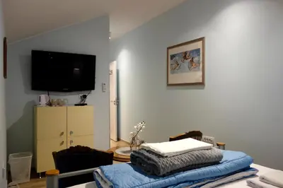 a living room with a tv on the wall and a table at Villa Loop Beograd in Belgrade