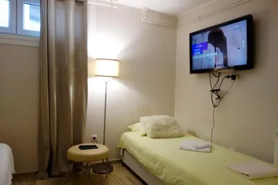 a bedroom with a bed and a tv on the wall at Villa Loop Beograd in Belgrade