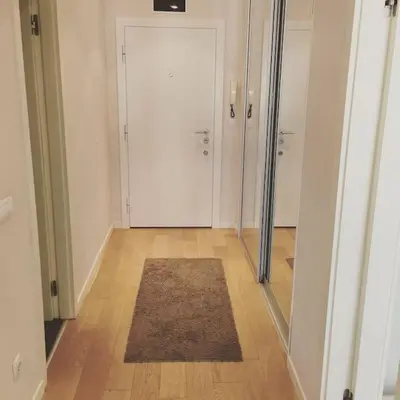 an empty hallway with a white door and a rug at Maya's Downtown Apartment in Belgrade