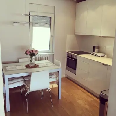 a kitchen with a table and a vase of flowers on it at Maya's Downtown Apartment in Belgrade