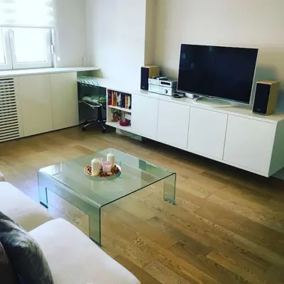 a living room with a tv and a glass coffee table at Maya's Downtown Apartment in Belgrade