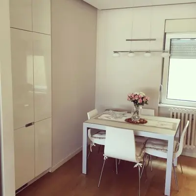 a white dining room with a table and chairs at Maya's Downtown Apartment in Belgrade