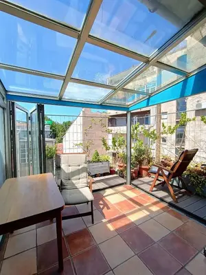 a conservatory with a table and chairs on a patio at On The Terrace La Vida Joy Mansard Top Kitchen in Belgrade