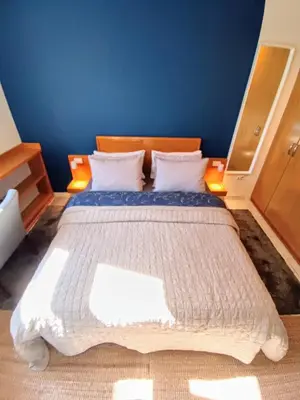 a bedroom with a large bed with a blue wall at On The Terrace La Vida Joy Mansard Top Kitchen in Belgrade