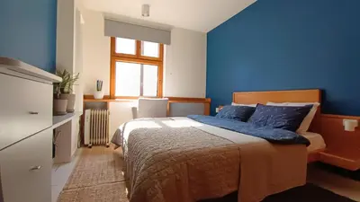 a bedroom with a bed with blue walls and a window at On The Terrace La Vida Joy Mansard Top Kitchen in Belgrade
