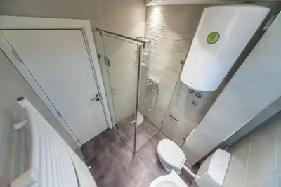 a bathroom with a toilet and a glass shower at Fontana Studio in Belgrade