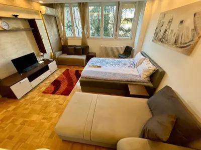 a living room with a bed and a couch at Fontana Studio in Belgrade