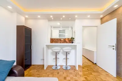 a kitchen with a white counter and two stools at Fontana Studio in Belgrade