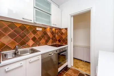 a kitchen with white cabinets and a sink at Fontana Studio in Belgrade