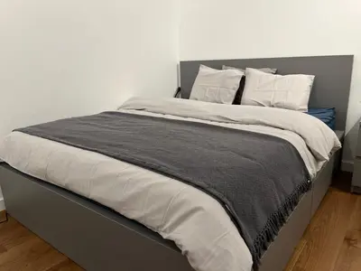 a bedroom with a large bed with white sheets and pillows at GardenGateStudio in Belgrade