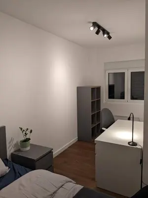 a white room with a bed and a desk at GardenGateStudio in Belgrade