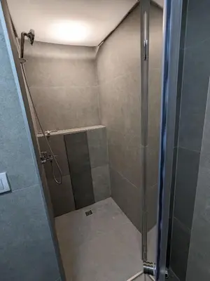 a shower with a glass door in a bathroom at GardenGateStudio in Belgrade