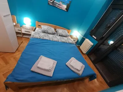 a bed in a blue room with two towels on it at G&S apartment in Novi Beograd