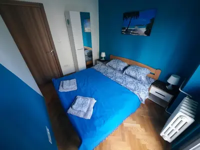 a blue bedroom with a bed with blue sheets at G&S apartment in Novi Beograd