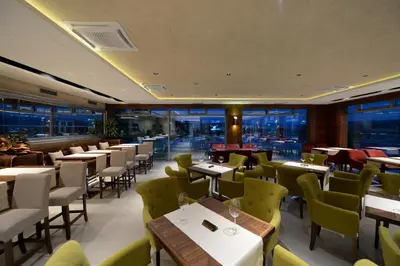 a restaurant with tables and chairs and windows at Hotel Hedonic in Belgrade