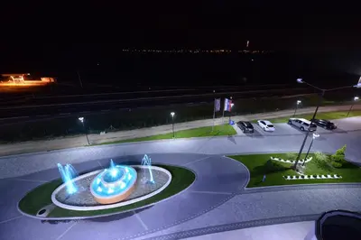 a fountain in the middle of a road at night at Hotel Hedonic in Belgrade