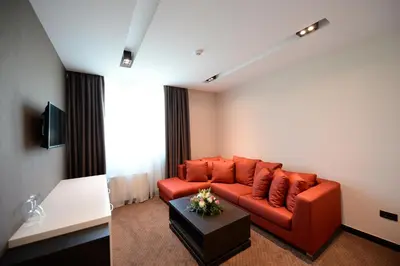 a living room with a red couch and a table at Hotel Hedonic in Belgrade