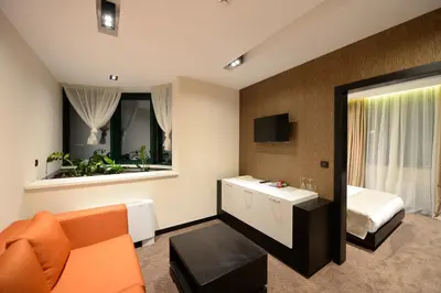 a hotel room with a bed and a couch at Hotel Hedonic in Belgrade