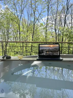 a laptop sitting on a table with a glass of wine at Chado Belgrade in Belgrade