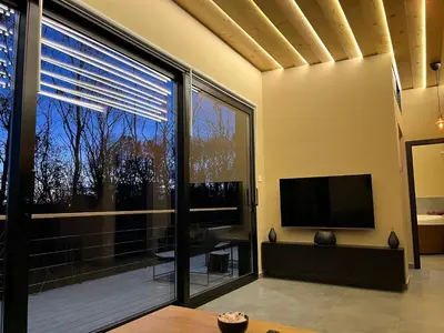 a living room with a large window and a flat screen tv at Chado Belgrade in Belgrade
