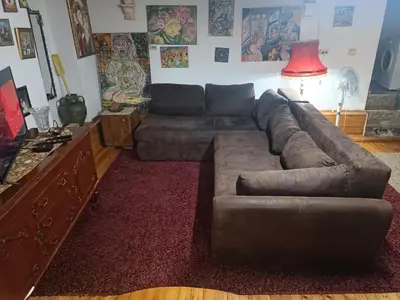 a living room with a brown couch and a red rug at Maravilja 23 in Filmski Grad